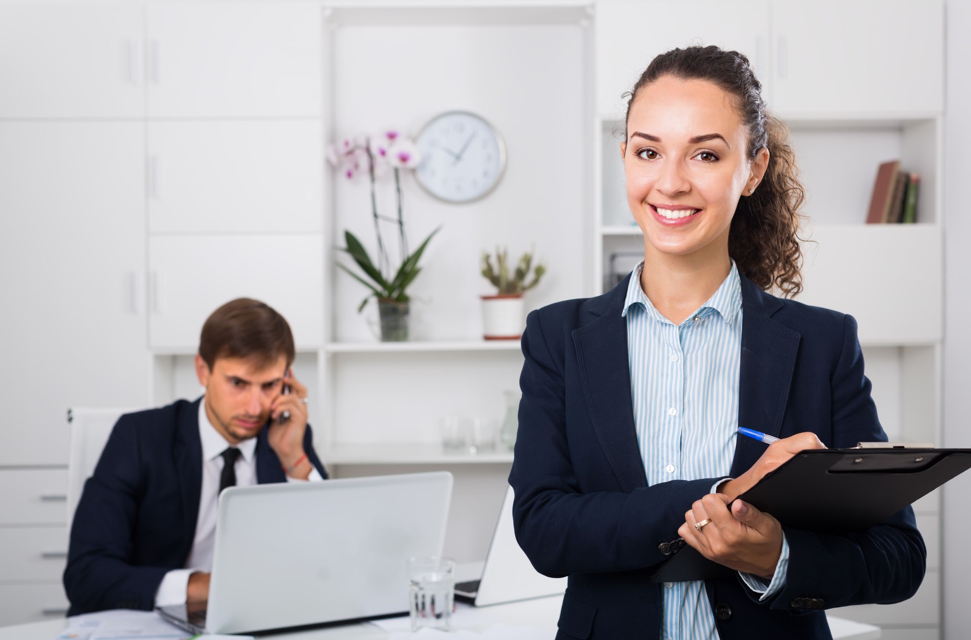 attractive young woman manager holding cardboard in office